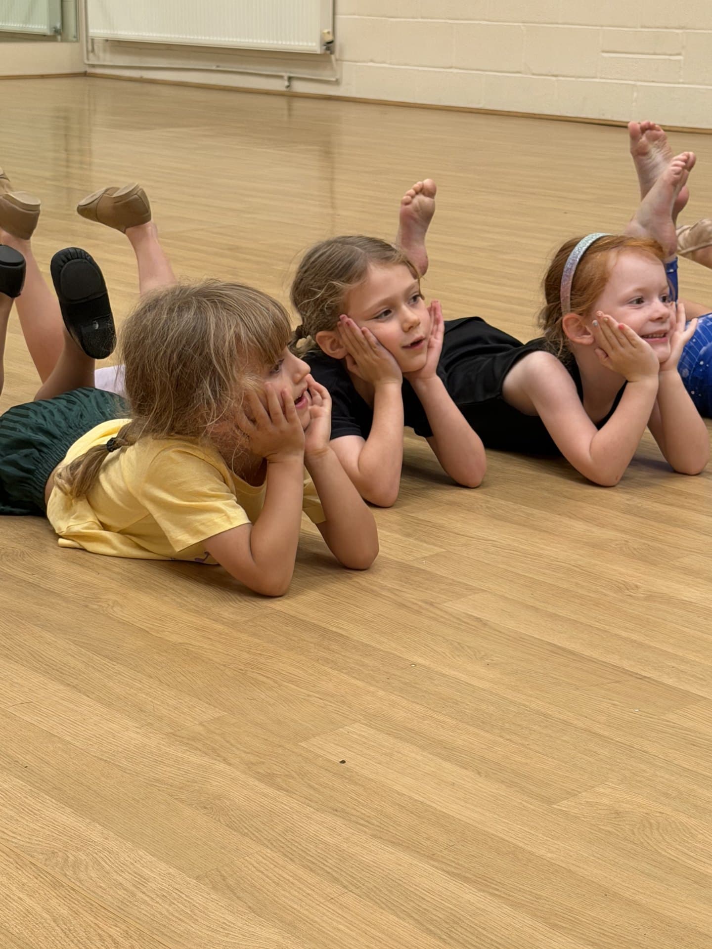Three holiday camp dancers lying on the studio floor