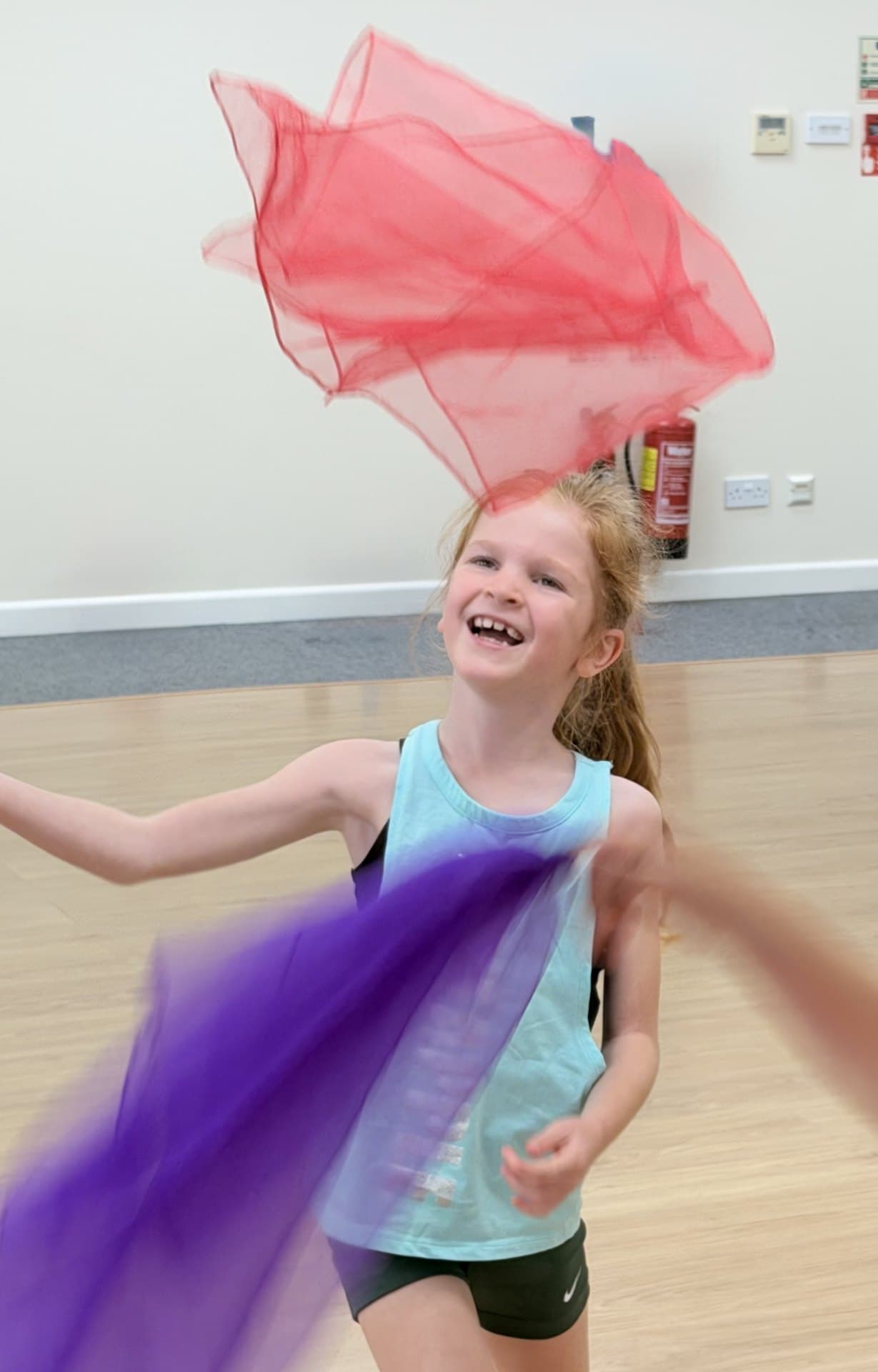 Holiday camp dancer laughing with colourful scarves