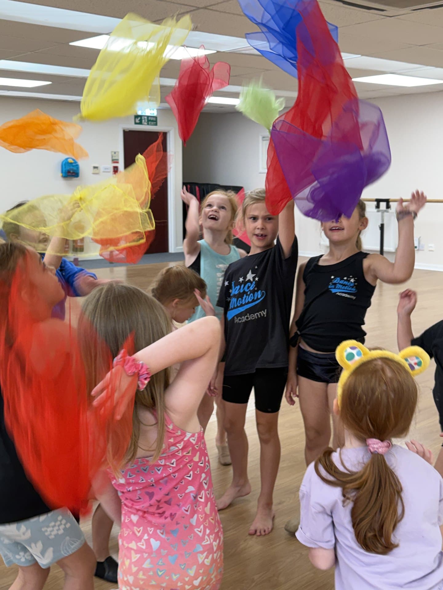 Holiday camp dancers tossing colourful scarves in the studio