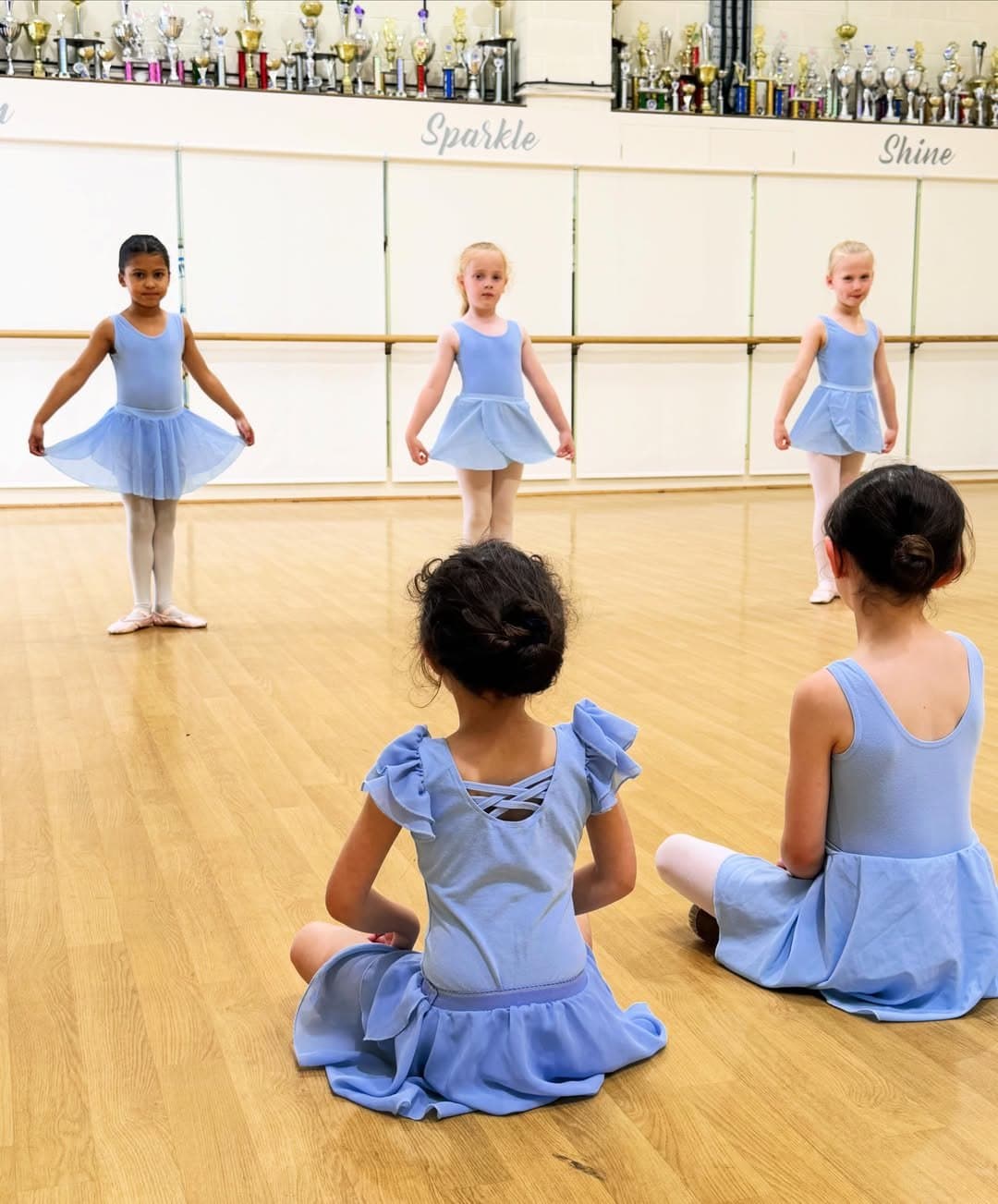 Young ballet students in pale blue leotards on exam day