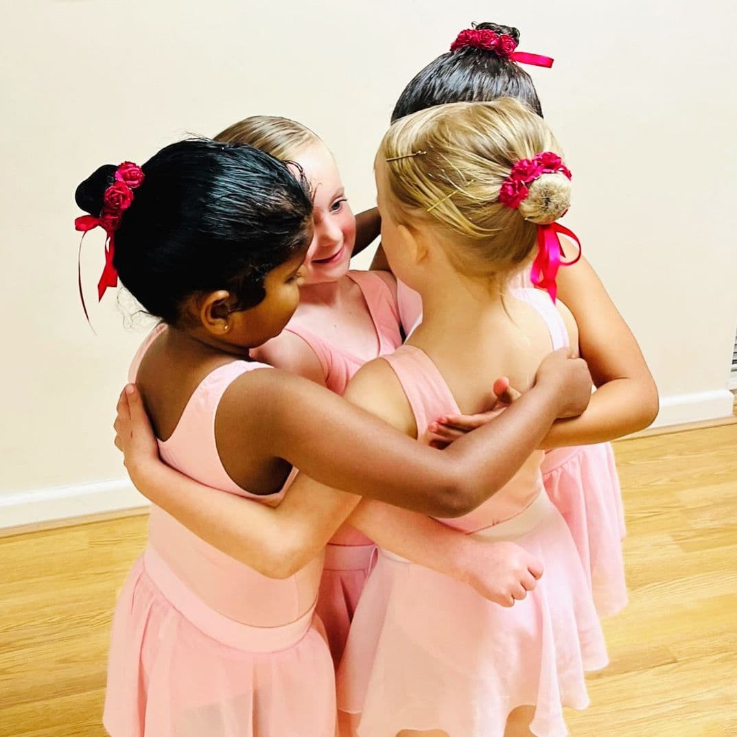 Pre-school ballet students sharing a group hug